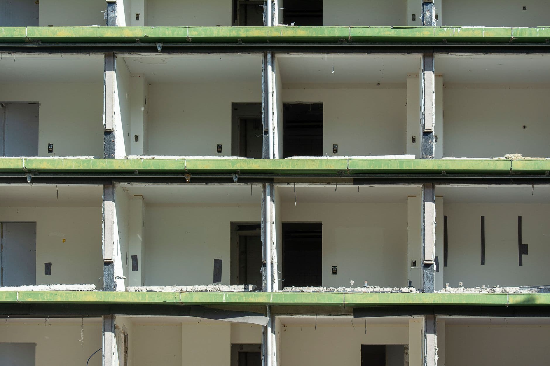 Gebouw zonder gevelbekleding, met lege verdiepingen, kale binnenmuren en puin op de vloerranden