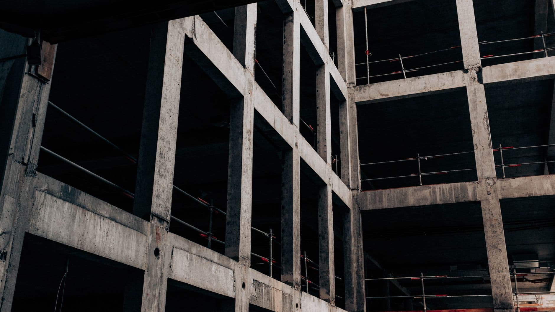 Betonnen skelet van een gebouw met kolommen, balken en leuningen, van onderuit gezien