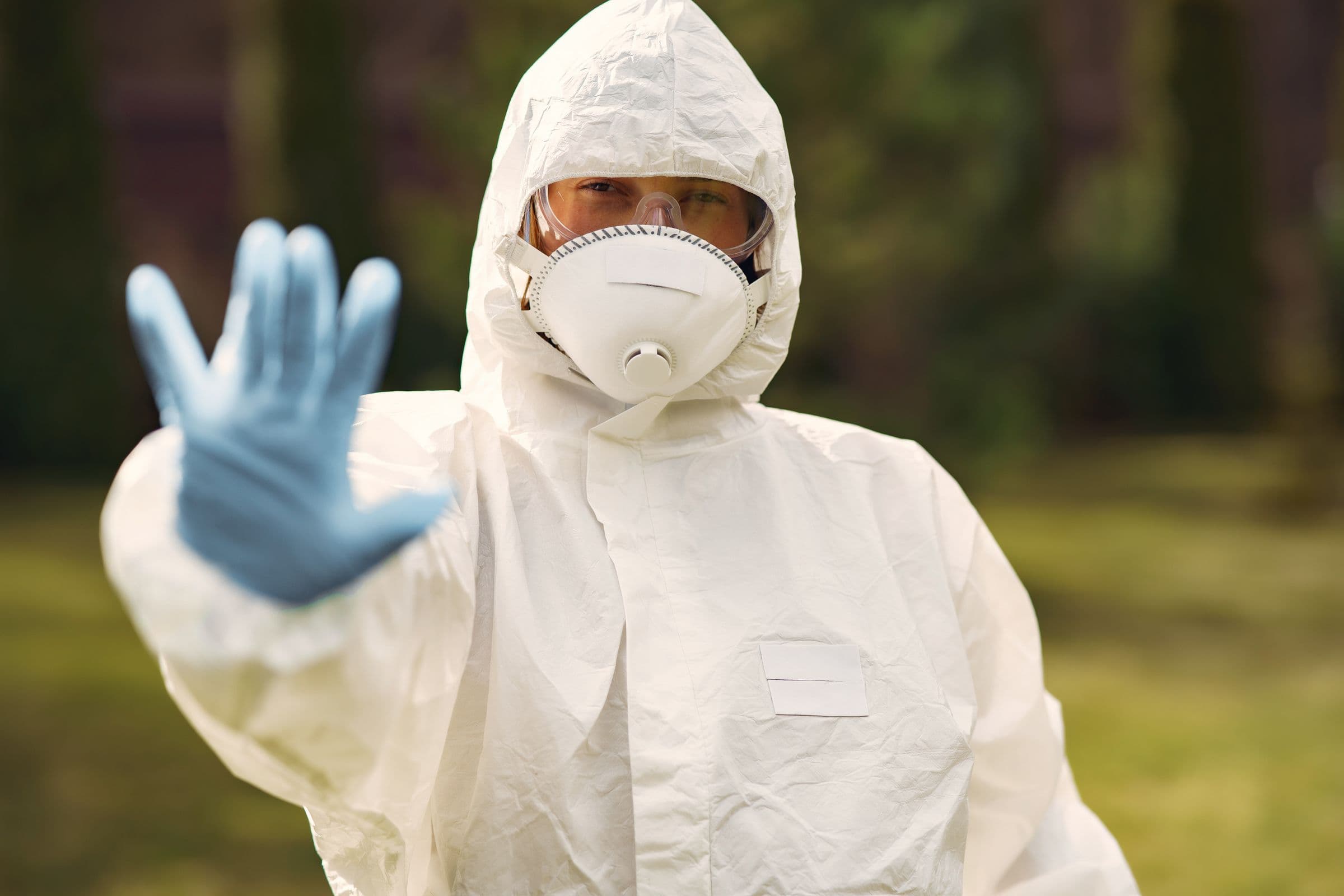 Vakman in wit beschermingspak met mondmasker